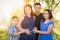 Affectionate Hispanic Pregnant Family Portrait Outdoors