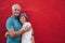 Affectionate mature couple together on red background