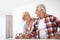 Affectionate senior couple with glasses of water at home