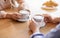 Affectionate young couple on date at cafe, drinking coffee together, cropped view of hands