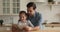 Affectionate young father reading book to small daughter.