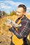 Affectionate young male farmer petting cat in countryside.