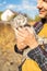 Affectionate young male farmer petting cat in countryside.