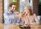 Affectionate young man feeding tasty croissant to his girlfriend at cozy cafe