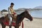 Afghan Rider on Horseback riding on lake shore