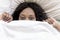 A Afraid black woman under bed blanket
