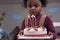 Africa American boy hold on celebrating him birthday cake and blow candles on cake in Kids birthday celebratiion party