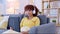 African adult woman video call at home on sofa. Lady greeting, smiling online with digital tablet and headphones. Girl