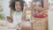 African America family with mother wearing apron rolling thresh flour for cooking with daughter together.