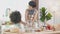 African America family with mother wearing apron thresh flour for cooking and dancing with daughter together.