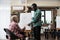 African american art teacher explaining draw illustration to senior woman