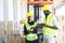 African American and Asian workers wearing safety vest while working in warehouse checking for the inventory