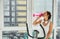 African American athletic woman drinking water from pink bottle to hydrate your body after morning cardio workout on a stationary