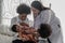 African american baby boy holding in hand of mother being examine by asian doctor with stethoscope
