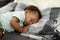 African American Baby Boy Sleeping On Side Lying In Bed