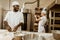 african american baker kneading dough at baking manufacture and chatting