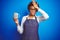 African american barista woman wearing bartender uniform holding cup over blue background stressed with hand on head, shocked with