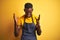 African american bartender man wearing apron standing over  yellow background celebrating mad and crazy for success with