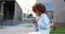 African American beautiful woman tapping and scrolling on mobile phone and sitting on bench outside. Stylish attractive