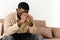 African American believing man sitting at home on sofa praying to God, asking for good luck, thoughtful bi-racial