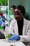 African american biologist scientist dropping liquid using micropipette in petri dish