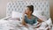 African american black beautiful smiling girl daughter sit on comfortable light bed with orthopedic mattress in bright