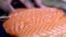 African American black hand cutting with a knife delicious gourmet raw salmon