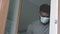 African american black man wearing medical mask standing by window looking outside. Quarantine and mental health concept