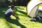 African american boy having fun pitching tent with ropes in sunny garden