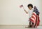 African American boy holding little usa flags standing with us blanket on his shoulder