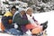 African American brothers and sister sliding on a sled.