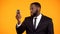 African-american businessman holding smartphone, mobile financial tool, app