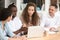 African American businessman mentor teaching interns, using laptop