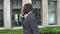African American Businessman talking on cell phone, standing in front of his office. slow motion