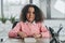 African american businesswoman with curly hair working with calculator in office