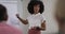 African american businesswoman standing at whiteboard giving presentation to colleagues