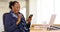 An African American businesswoman uses her mobile phone at her desk