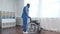 African-American caregiver and an empty wheelchair. Professional nurse in a nursing home. Assistance, rehabilitation and