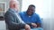 African-American caregiver and old disabled man in a wheelchair. Professional nurse and handicapped patient in a nursing