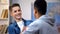 African-american and caucasian teenage boys handshaking, happy to see each other