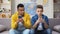 African-American and Caucasian teens playing games on phones, showing results