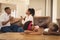 African American children leaning on table while parents arguing on the sofa