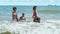 African-American children Playing the sea waves on the beach merrily on a summer holiday