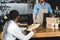 african american client holding blank clipboard and looking at bearded barista