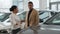 African American couple buying new car in auto showroom woman seller manager dealer saleswoman consult man client to