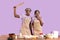 African American couple feeling shocked while baking together on lilac studio background