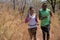 African american couple having trail running together in forest