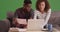 African American couple pays their bills on their laptop on green screen