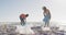 African american couple segregating waste together on dirty sunny beach