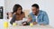 African American couple showing and discussing over mobile phone while having lunch